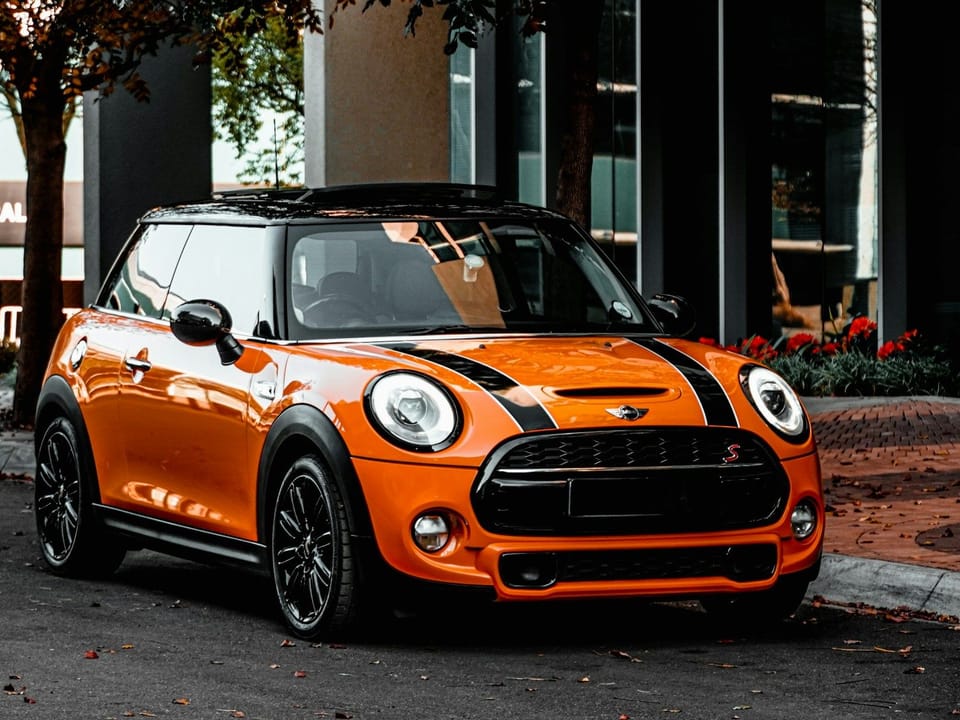 Оранжевый MINI Cooper на городской улице