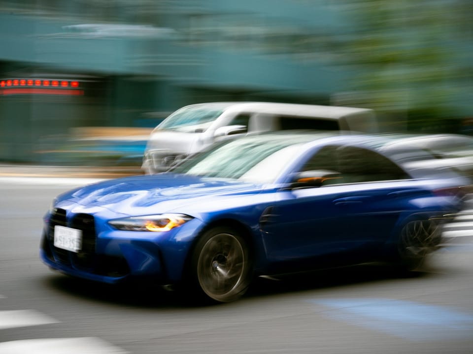 Синий BMW 3 серии в движении по городской улице